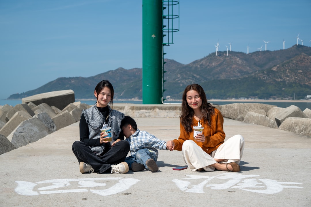 two women sitting on the ground with a child
