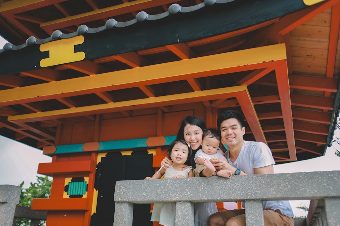 Family posing in front of a colorful japanese pagoda.